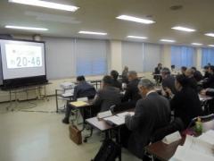 第3回会議で、参加者が手元の資料と、前方にあるプロジェクタースクリーンを見ている写真