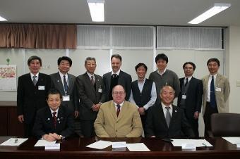 スーツを着た男性や関係者の集合写真