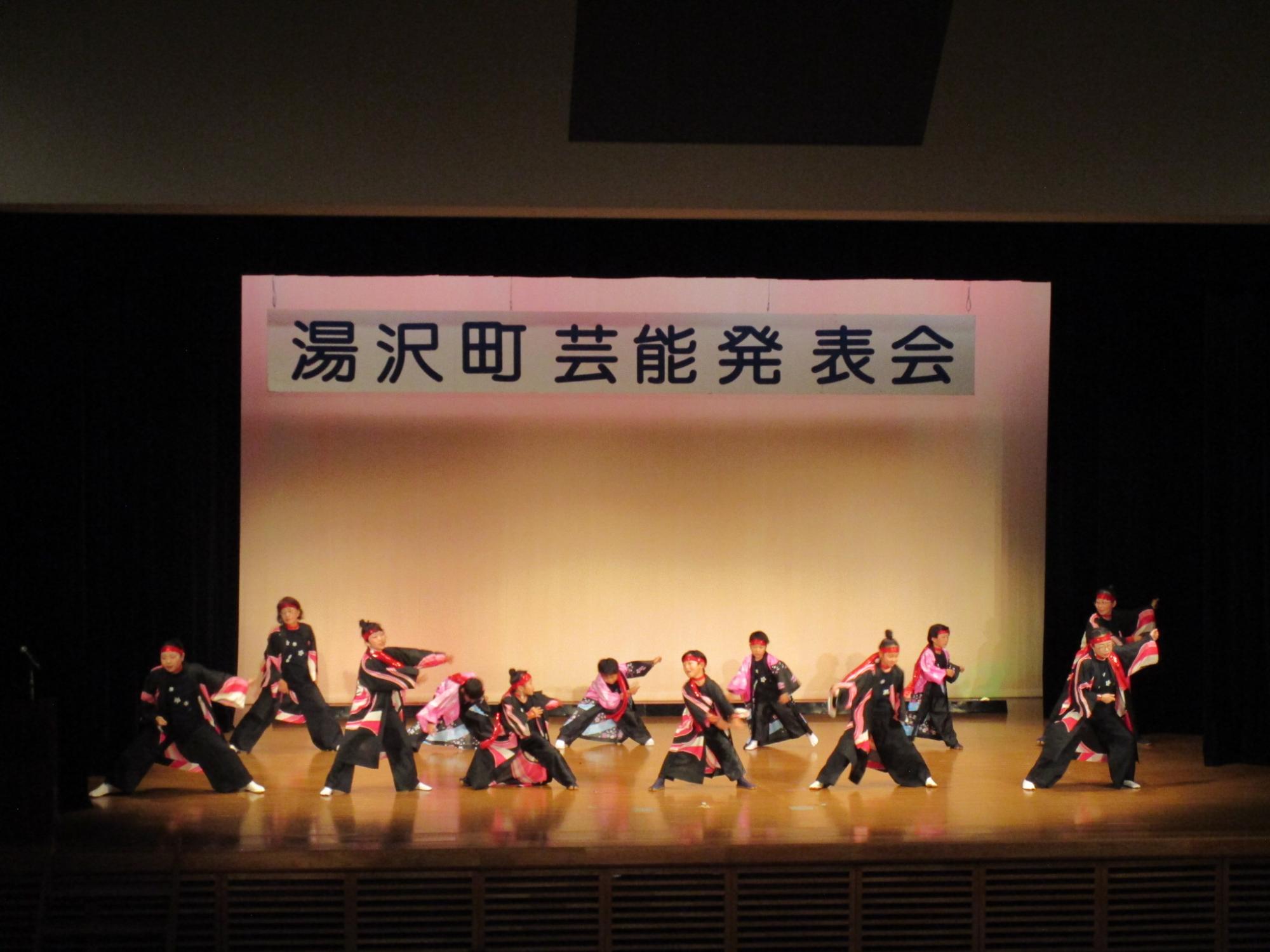 舞台でよさこいを踊るよさこい湯沢雪華のメンバーの写真
