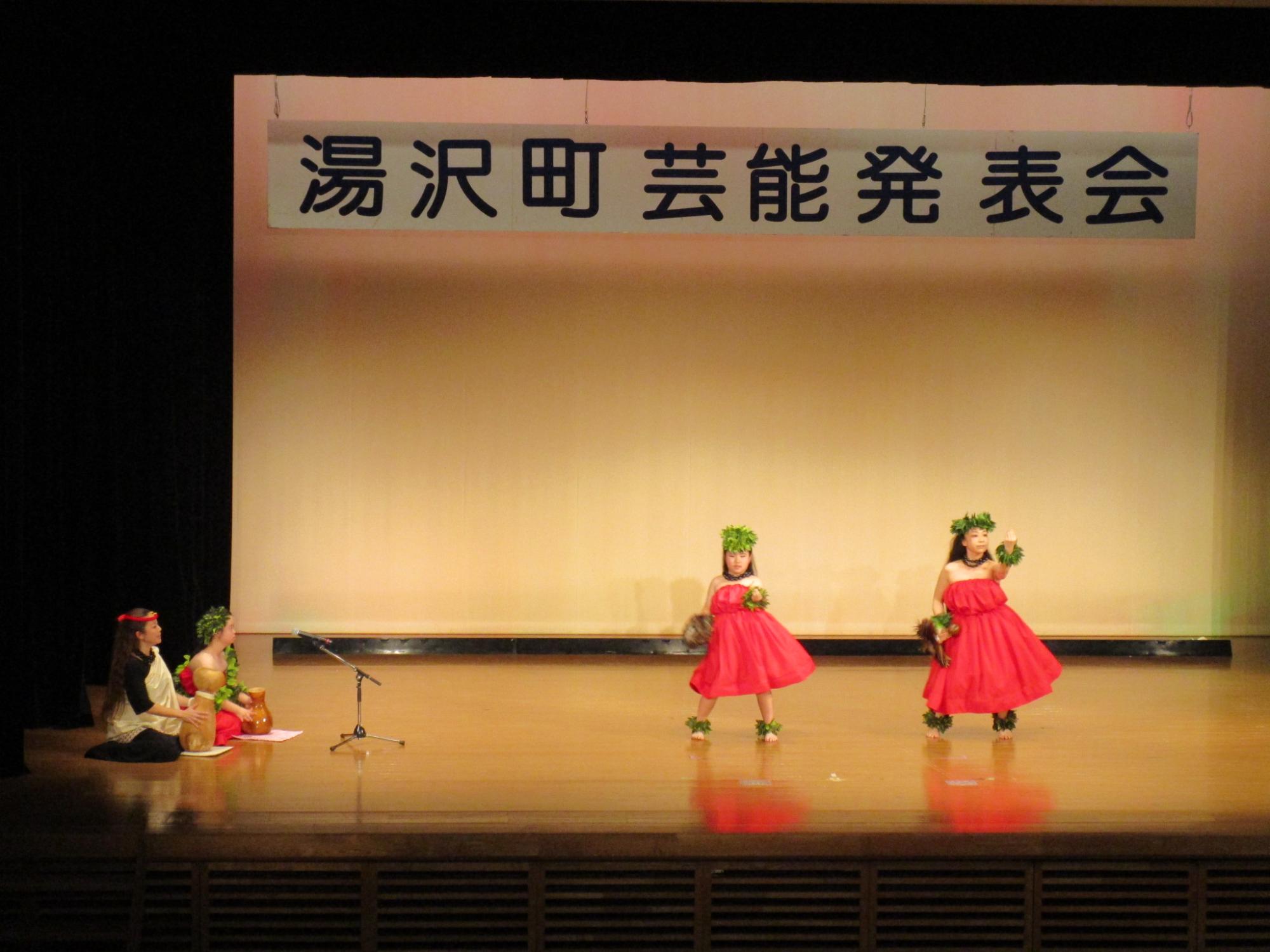 舞台でフラダンスを踊るプルメリアのメンバーの写真