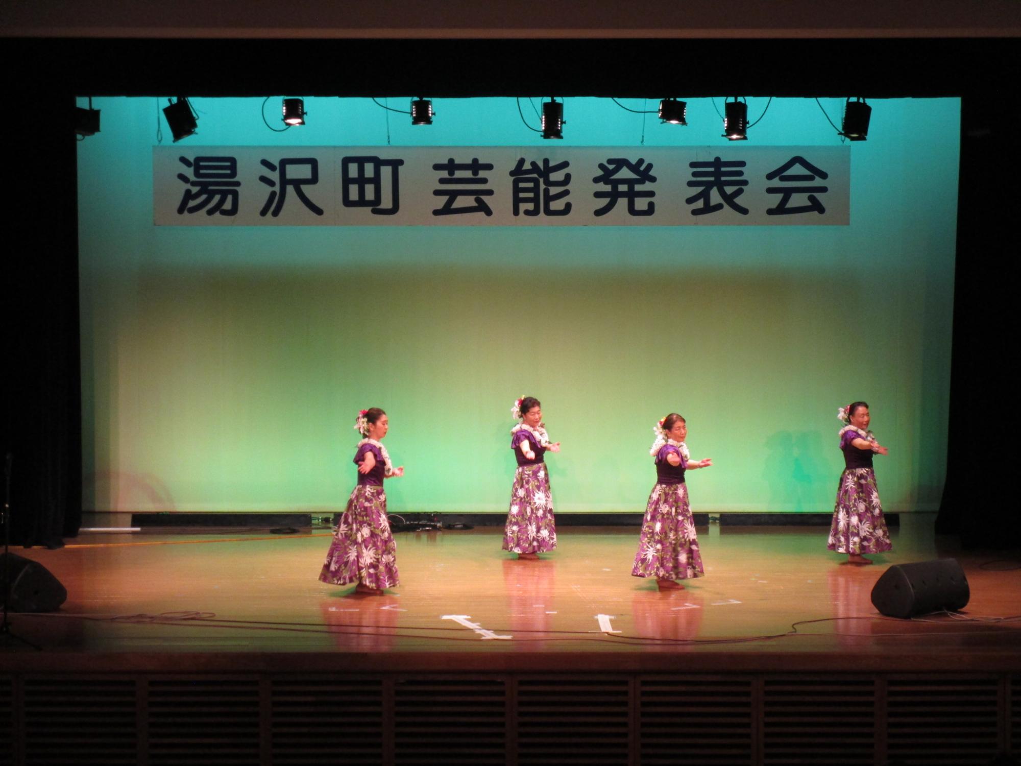 舞台でフラダンスを踊るフラレフアナニのメンバーの写真