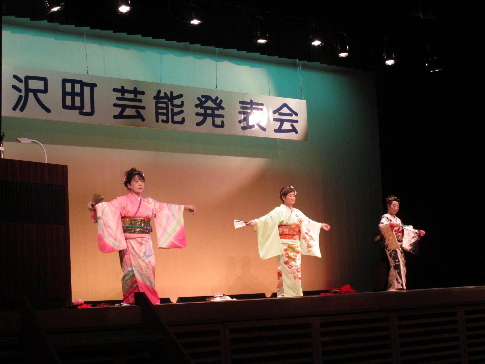 舞台で踊る雪国演芸友の会のメンバーの写真