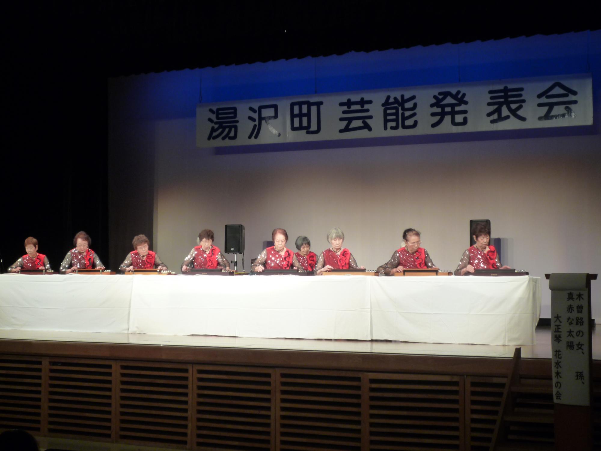 舞台の上で大正琴を演奏する花水木の会のメンバーの写真