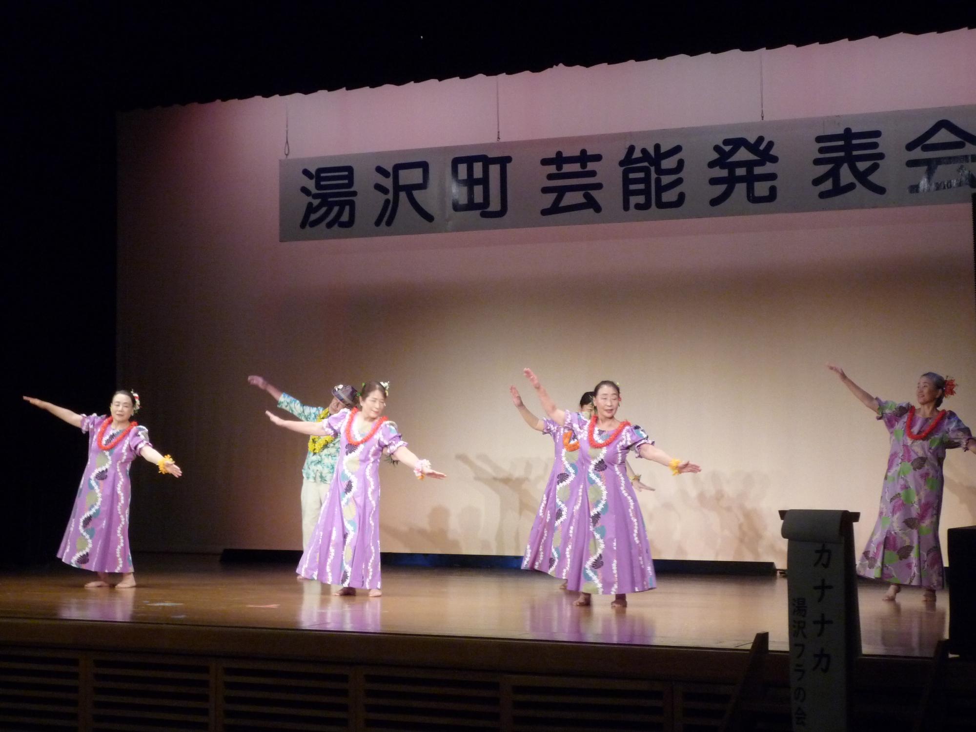 舞台でフラダンスを踊る湯沢フラの会のメンバーの写真