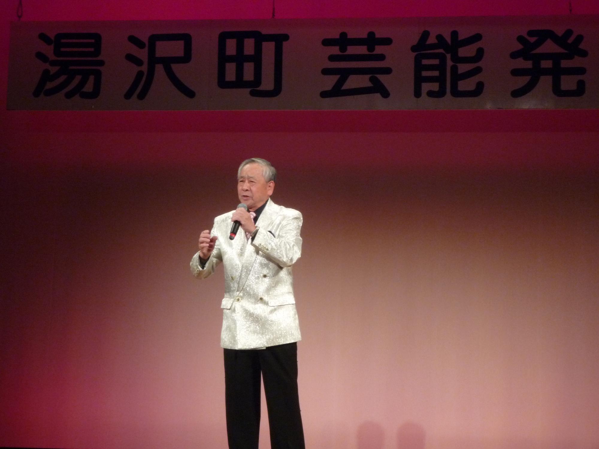 舞台で歌唱する田村演歌教室のメンバーの写真
