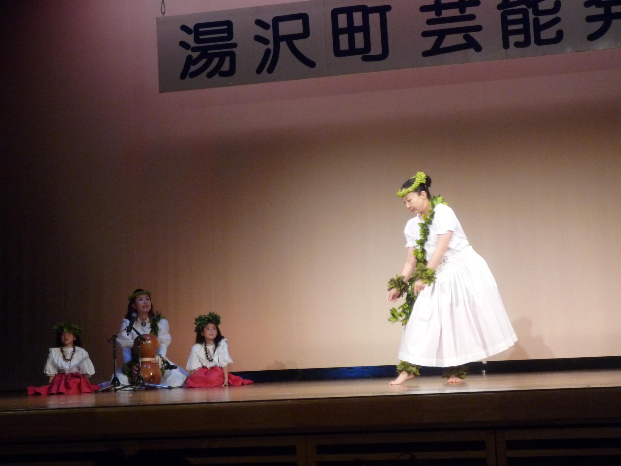 舞台でフラダンスをするフラの会プルメリアのメンバーの写真