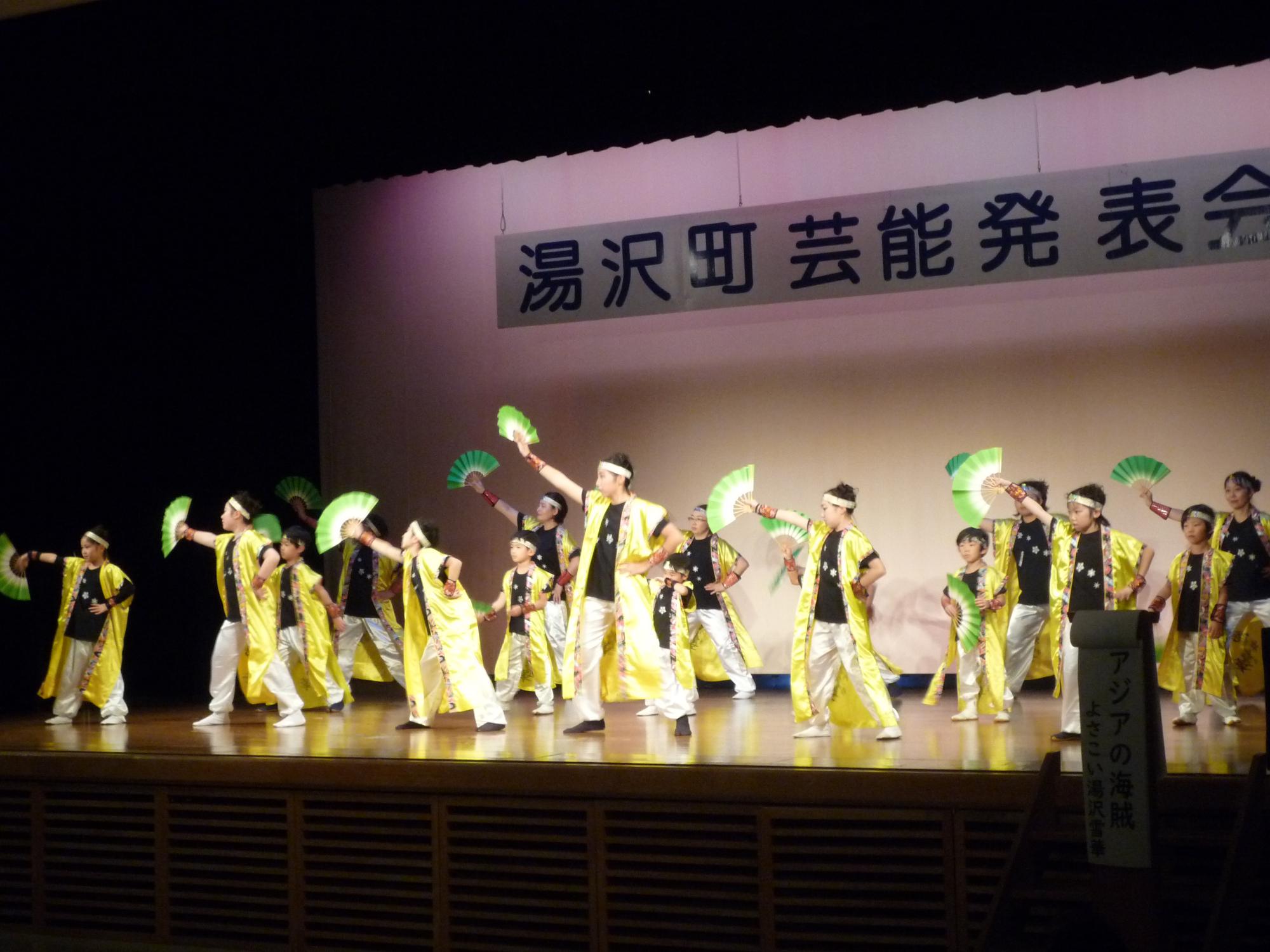 舞台でよさこいを踊るよさこい湯沢雪華のメンバーの写真