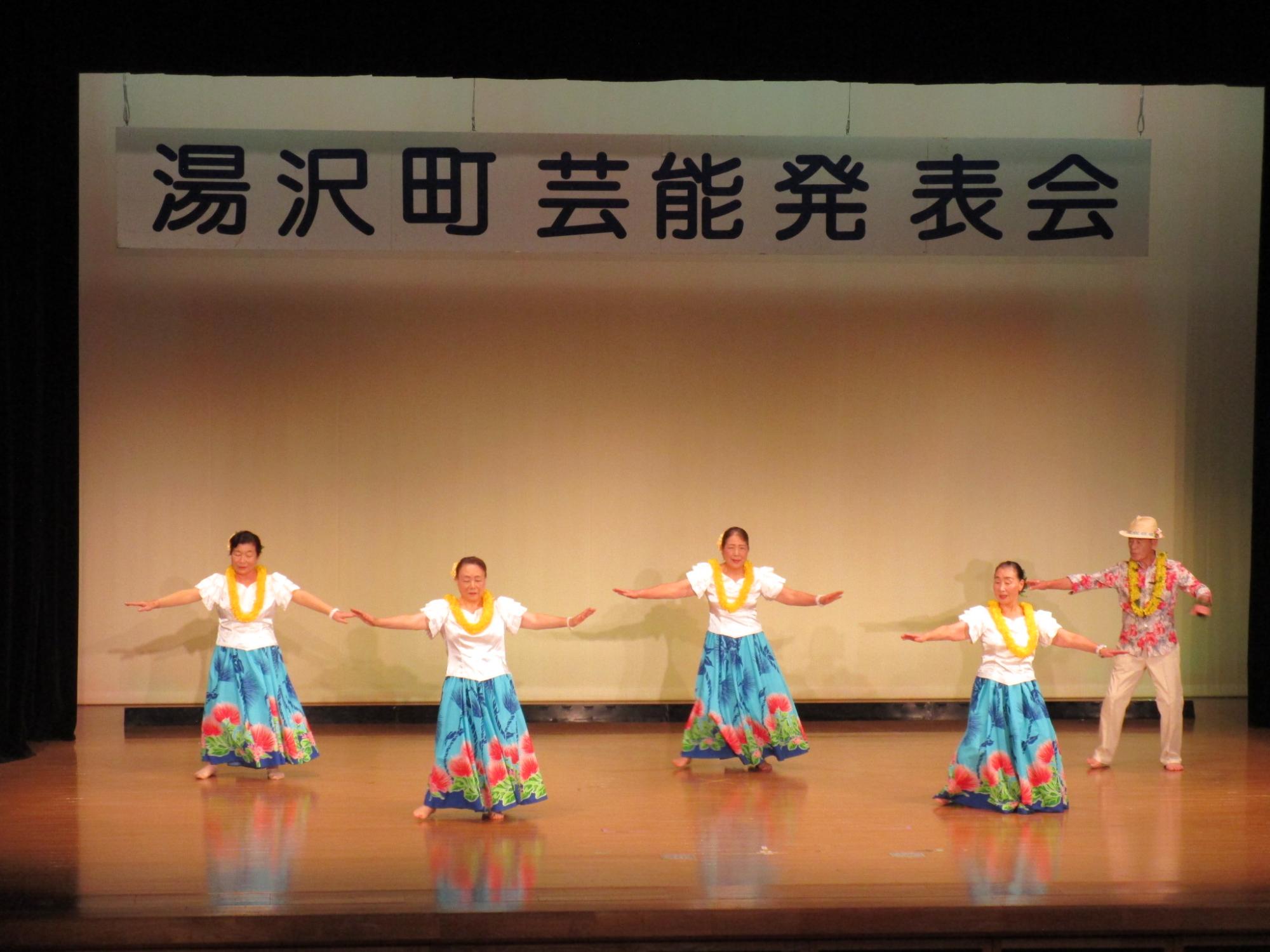 舞台でフラダンスを踊るフラレフアナニのメンバーの写真
