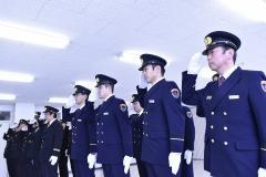 消防の制服を着た消防隊員の方々が整列しており、右手の平を下に向けて顔の横に置いて敬礼をしている消防出初式の写真