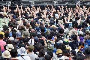 ステージ前にいる沢山のお客さんが、音楽に合わ大きく手を挙げて楽しんでいる様子を背後から写している写真