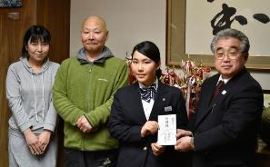 町長と金井選手が激励金を手に持ち、金井選手とご家族が一緒に写っている写真