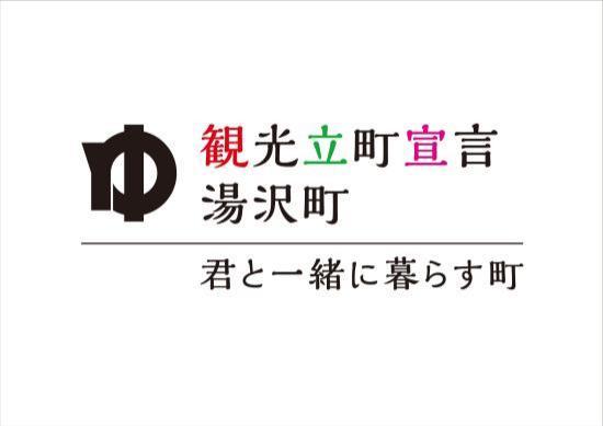 上段に「観光立町宣言湯沢町」下段に「 君と一緒に暮らす町」と書かれたスローガン